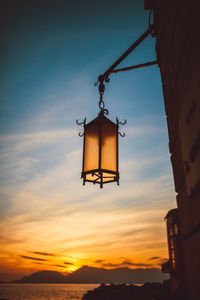 Lamp hanging against sky at sunset