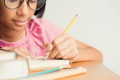 Midsection of woman reading book on table