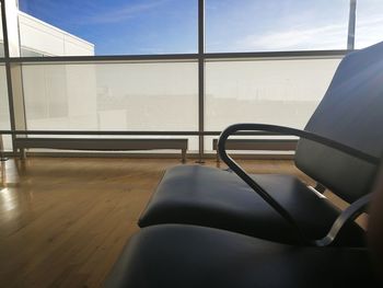 Empty chairs and table against window