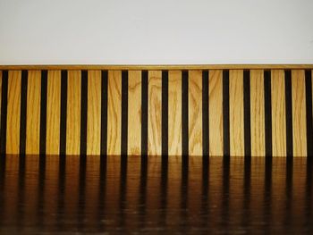 Close-up of wooden table against wall