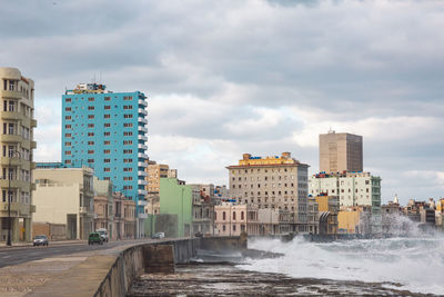 Buildings by sea against sky in city