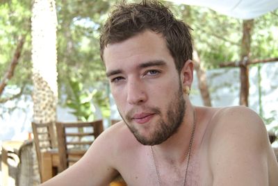 Close-up portrait of young man against trees