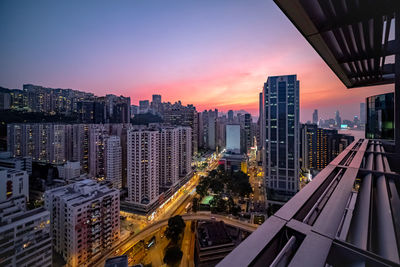 High angle view of modern buildings in city against sky during sunset