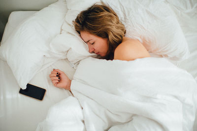 High angle view of woman sleeping on bed