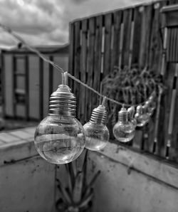 Close-up of light bulb hanging on wood