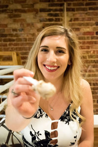 Portrait of smiling young woman feeding food