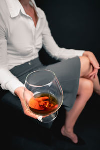 Midsection of woman holding wineglass