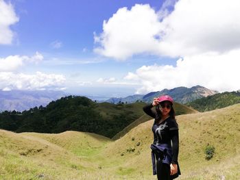 Woman standing on mountain against sky