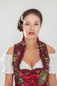 Portrait of beautiful young woman standing against white background