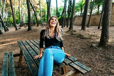 Happy young woman sitting on table