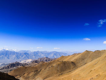 Scenic view of mountains against blue sky