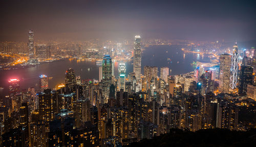 Illuminated cityscape against sky at night