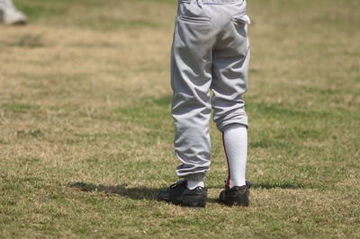 Boys legs wearing uneven baseball pants