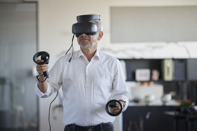 Businessman playing with virtual headset at work place