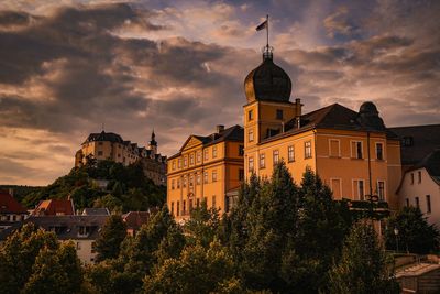 Two castles against sky during sunset in city