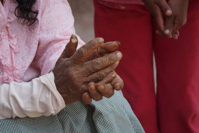 Midsection of woman with hands clasped