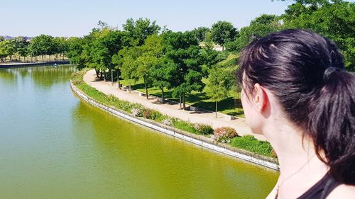 Portrait of woman by lake against trees