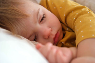 Close-up of cute baby boy sleeping on bed at home