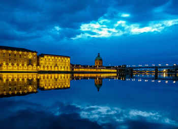 Illuminated city against sky at dusk