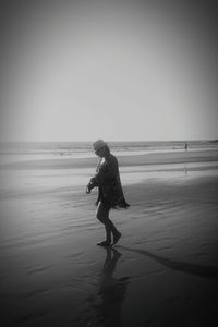 Full length of man on beach against clear sky