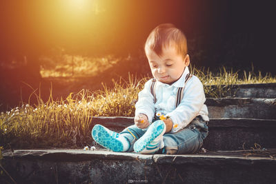 Full length of cute baby boy sitting outdoors