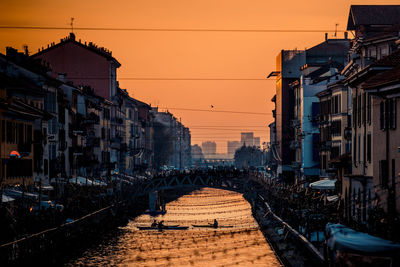 Street amidst buildings against sky during sunset