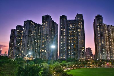 Illuminated buildings in city against sky at night