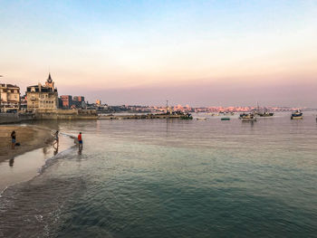 View of buildings in sea at sunset