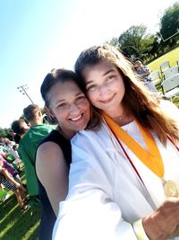 Portrait of smiling young woman against sky