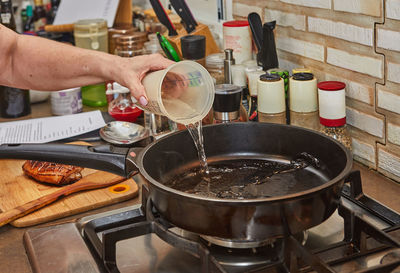 Cropped hand preparing food in kitchen