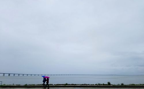 People on beach against sky