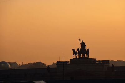 Silhouette of statue against sky during sunset