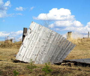 Abandoned barn on field against sky