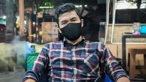 Portrait of young man standing in restaurant