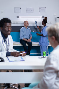 Midsection of doctor examining patient in office