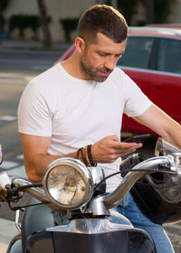 Man holding camera while sitting in car