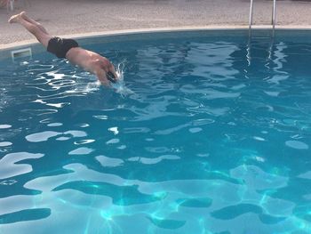 Low section of man swimming in sea