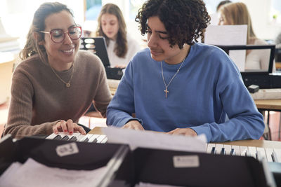 Teenagers attending keyboard lesson