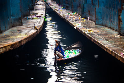 Rear view of woman in boat on canal