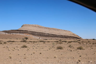 Sand dunes in desert against clear blue sky