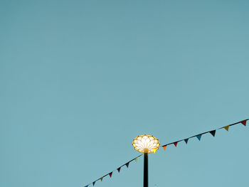 Low angle view of illuminated lamp against clear sky