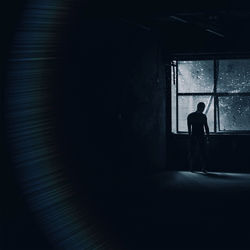Silhouette woman standing in window
