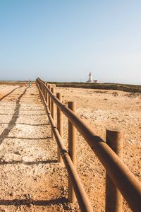 View of wooden fence on landscape against clear sky