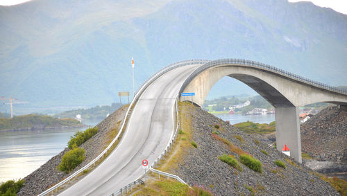 Road by bridge in city against sky