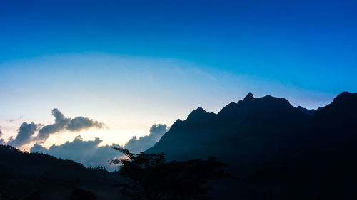 Scenic view of silhouette mountains against sky at sunset