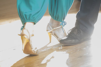 Low section of people standing on hardwood floor