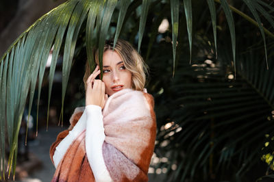 Fashionably dressed blonde-haired young woman in a park on an autumn day