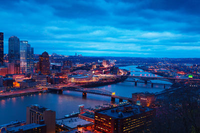 High angle view of illuminated city against sky at dusk