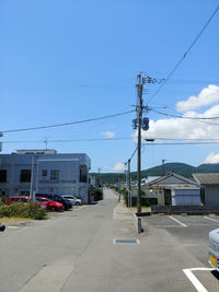 Street by buildings against sky in city