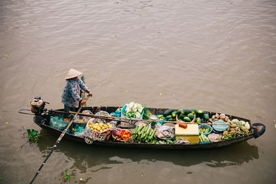 High angle view of man with vegetables in boat